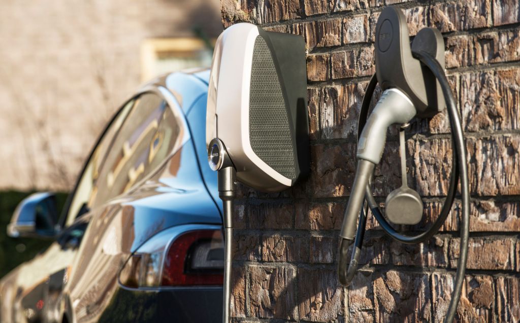 EVBox Elvi met een Tesla Model S op de achtergrond